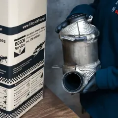 Osoba w rękawiczkach trzyma filtr DPF/FAP obok kartonu z logo Bosch Service.