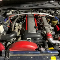 Silnik 2JZ-GE z turbosprężarką w Toyota Mark II. Widoczny czerwony filtr stożkowy i metalowe przewody dolotowe.