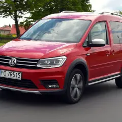Czerwony Volkswagen Caddy 3 w ruchu, z widocznymi felgami i terenowym wyglądem.