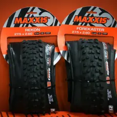 Dwie opony rowerowe Maxxis Rekon i Forekaster 27.5 x 2.60 na pomarańczowym tle.