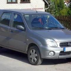 Szary Subaru Justy G3X stoi na drodze, gotowy na przygodę.