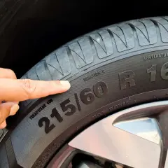 Palec wskazujący na oznaczenie opony 215/60 R16.
