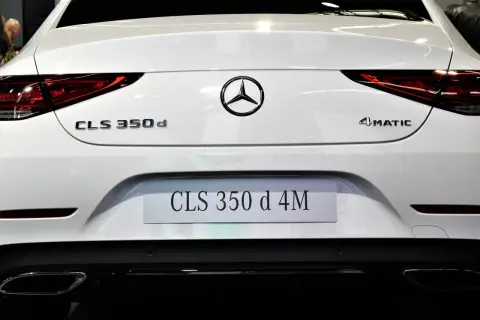Tył białego Mercedesa CLS 350 d 4MATIC. Widoczne oznaczenia modeli i logo marki.