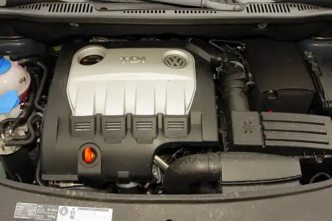 Silnik TDI z Volkswagena Touran 1T2. Widoczny jest srebrny dekiel z logo TDI i VW, przewody oraz zbiornik płynu chłodniczego.
