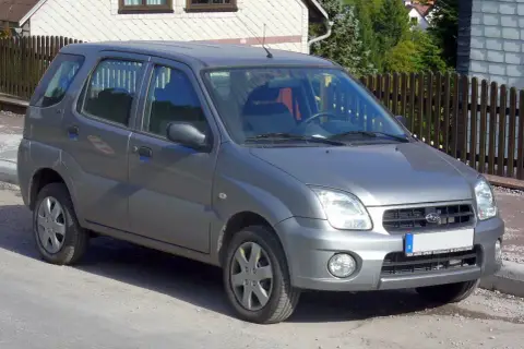 Szary Subaru Justy G3X stoi na drodze, gotowy na przygodę.