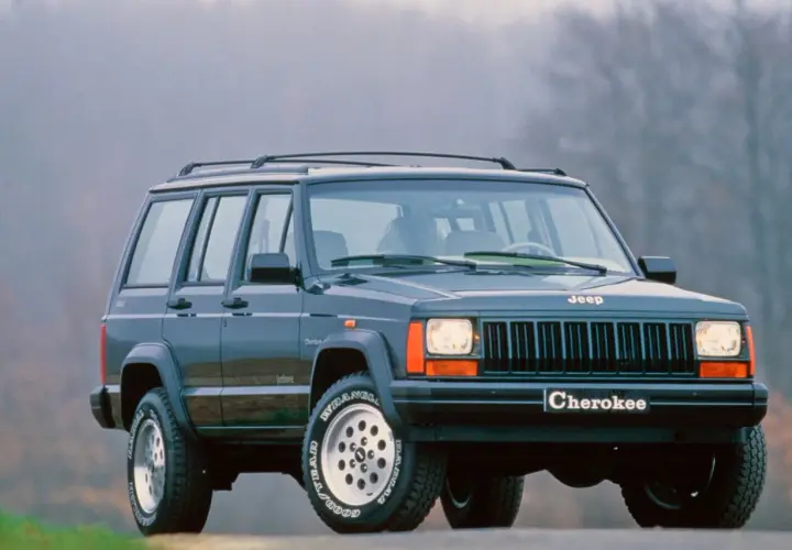 Klasyczny Jeep Cherokee ZJ z lat 90. na tle mglistego krajobrazu.