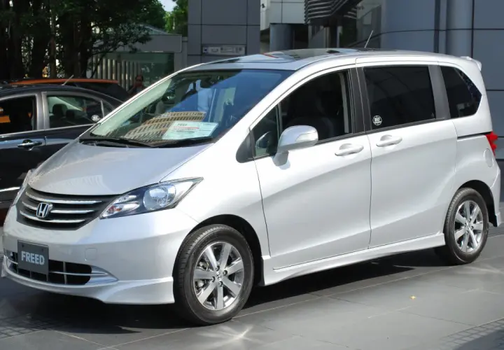 Srebrny Honda Freed stoi na tle budynku.