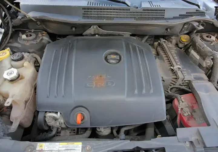Silnik 2.0L CRD w Dodge Caliber. Widoczne zbiorniczki płynów i akumulator.