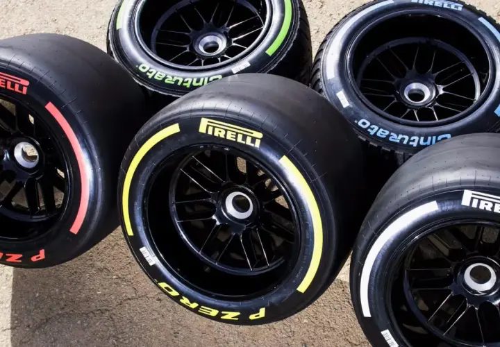 Pięć opon Pirelli F1 z kolorowymi paskami na bokach: czerwonym, żółtym, niebieskim, zielonym i białym.