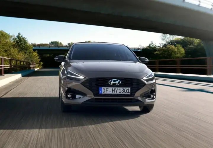 Szary Hyundai i30 GD jedzie po moście wśród zieleni.