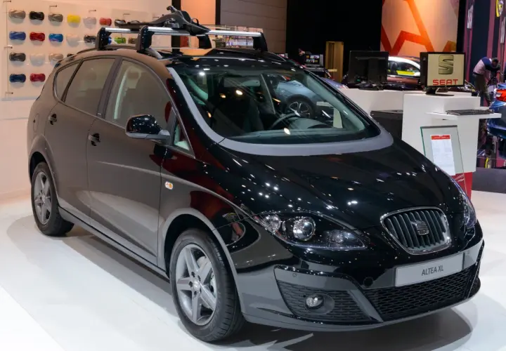 Czarny Seat Altea XL z relingami dachowymi, prezentowany na wystawie motoryzacyjnej.