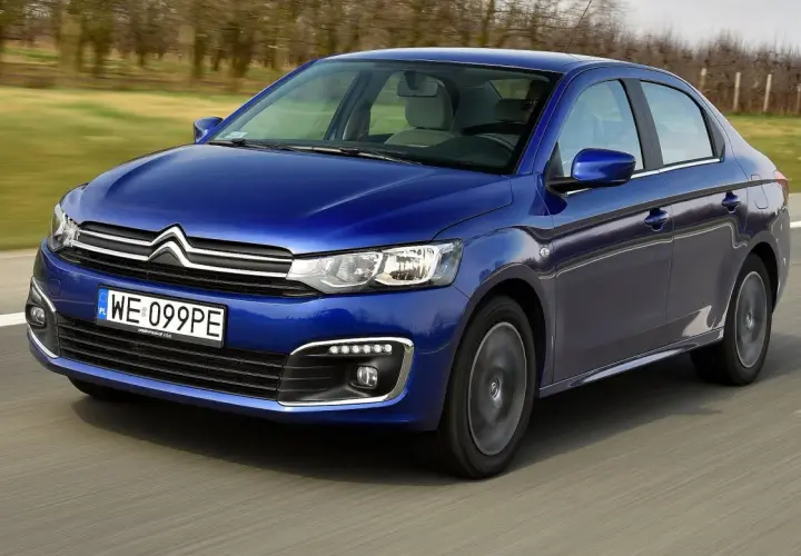 Niebieski Citroen C-Elysée jedzie po drodze, rozmyte tło sugeruje ruch.