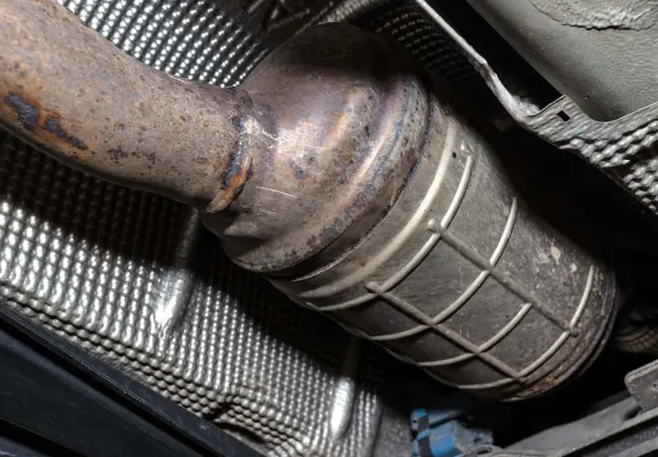 Podwozie auta z wyciętym DPF. Widoczny skorodowany katalizator i osłona termiczna.