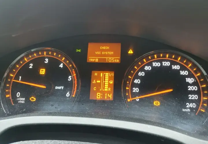 Kontrolki na desce rozdzielczej Toyota T27: CHECK VSC SYSTEM, kontrolka silnika, kontrolka ESP i hamulca. Przebieg 10.5 km.