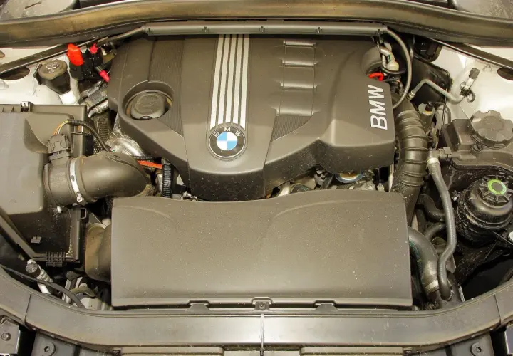Silnik BMW X1 E84 z widocznym logo BMW i elementami układu dolotowego.