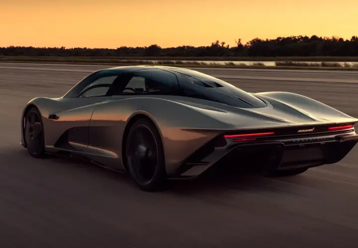 Szary McLaren Speedtail pędzi po pustej drodze o zachodzie słońca.