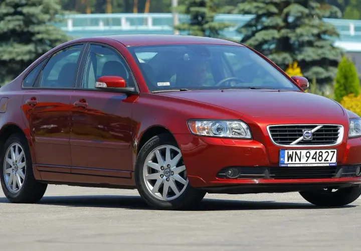 Czerwone Volvo S40 II z polskimi tablicami rejestracyjnymi WN 94827 zaparkowane na zewnątrz.
