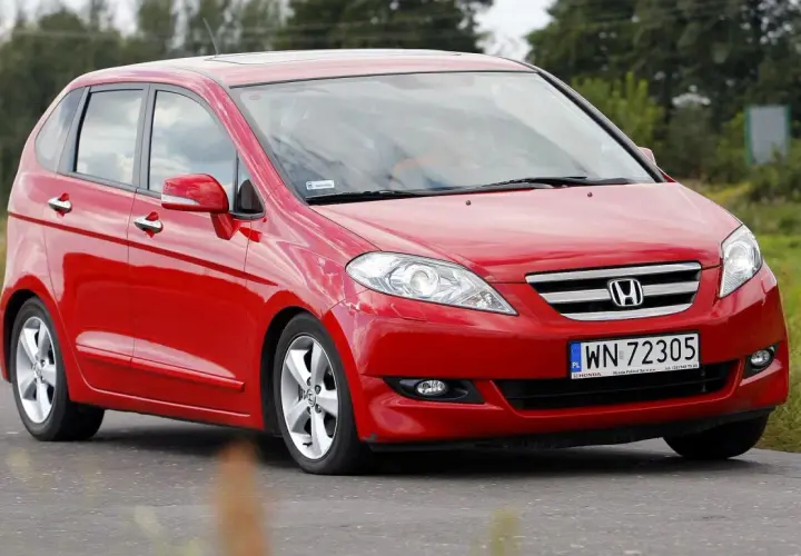 Czerwona Honda FR-V w ruchu drogowym, z widocznym numerem rejestracyjnym WN 72305.