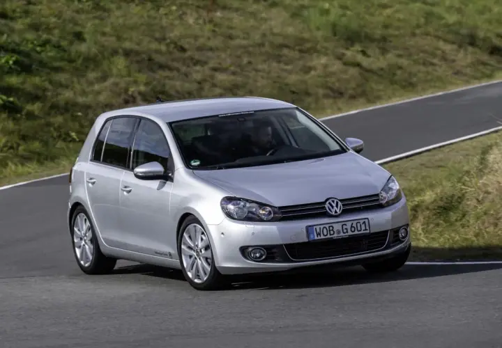 Srebrny Volkswagen Golf VI, produkowany w latach 2008-2013, pokonuje zakręt na torze wyścigowym.