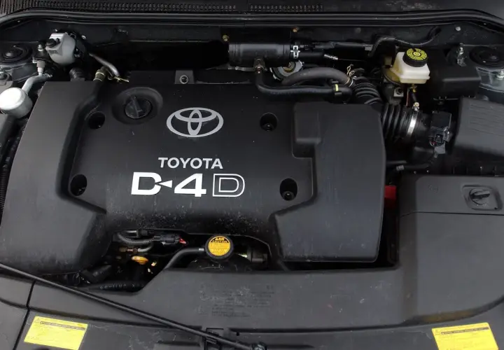 Silnik D-4D w Toyocie Avensis T25. Widoczna czarna pokrywa silnika z logo Toyoty i napisem D-4D.
