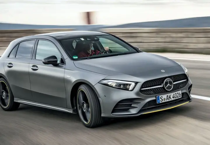 Szary Mercedes W177 pędzi po torze, kierowca w czerwonej koszuli pewnie trzyma kierownicę.