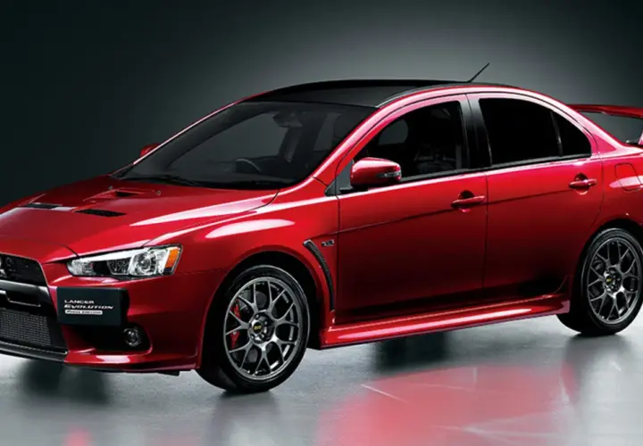 Czerwony Mitsubishi Lancer Evolution z czarnym dachem i spoilerem, gotowy do jazdy.