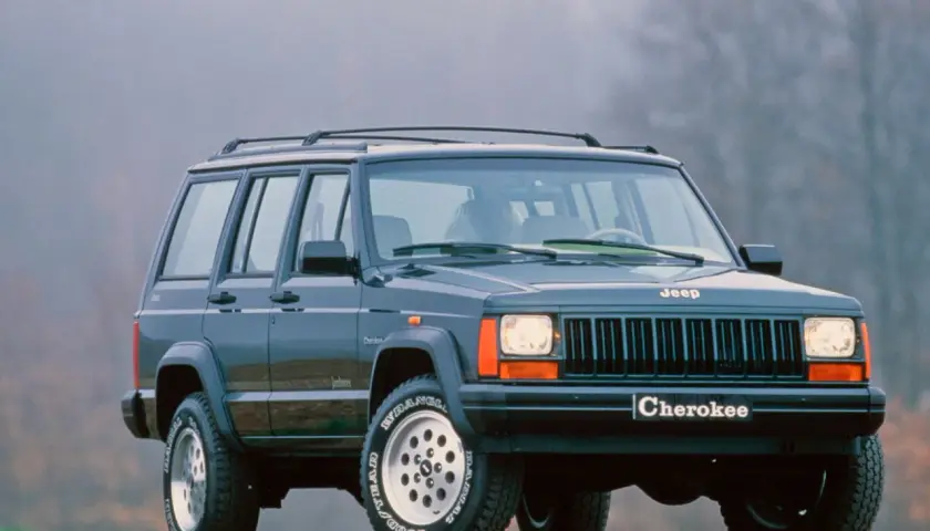 Klasyczny Jeep Cherokee ZJ z lat 90. na tle mglistego krajobrazu.