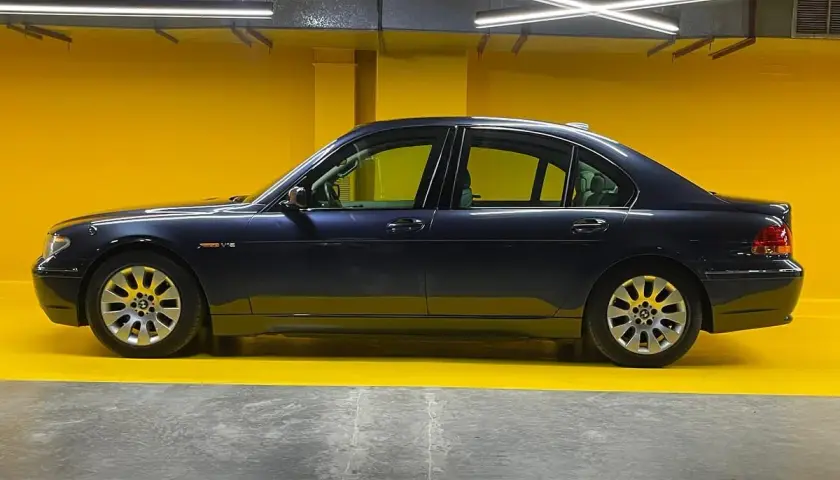 Eleganckie bmw e67 w ciemnym kolorze, zaparkowane na tle jaskrawożółtej ściany.
