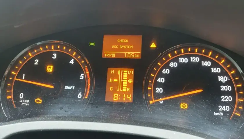 Kontrolki na desce rozdzielczej Toyota T27: CHECK VSC SYSTEM, kontrolka silnika, kontrolka ESP i hamulca. Przebieg 10.5 km.