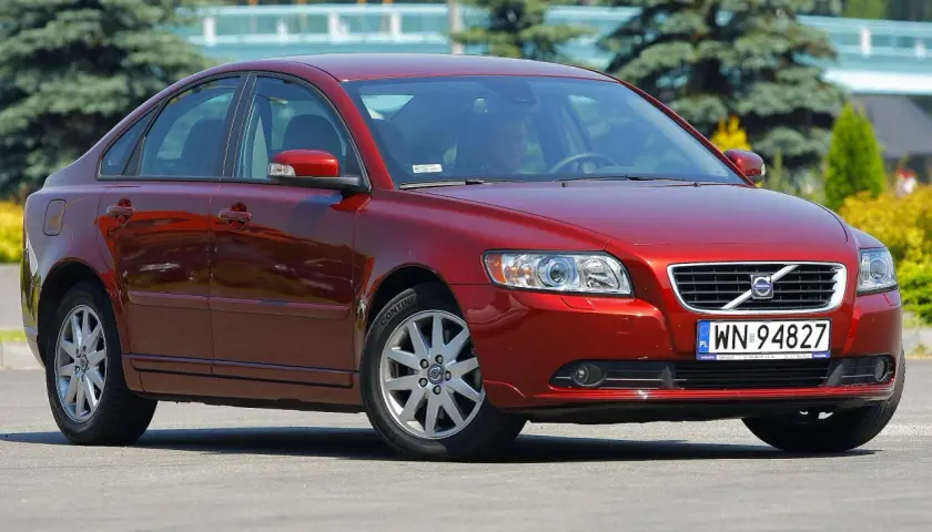 Czerwone Volvo S40 II z polskimi tablicami rejestracyjnymi WN 94827 zaparkowane na zewnątrz.