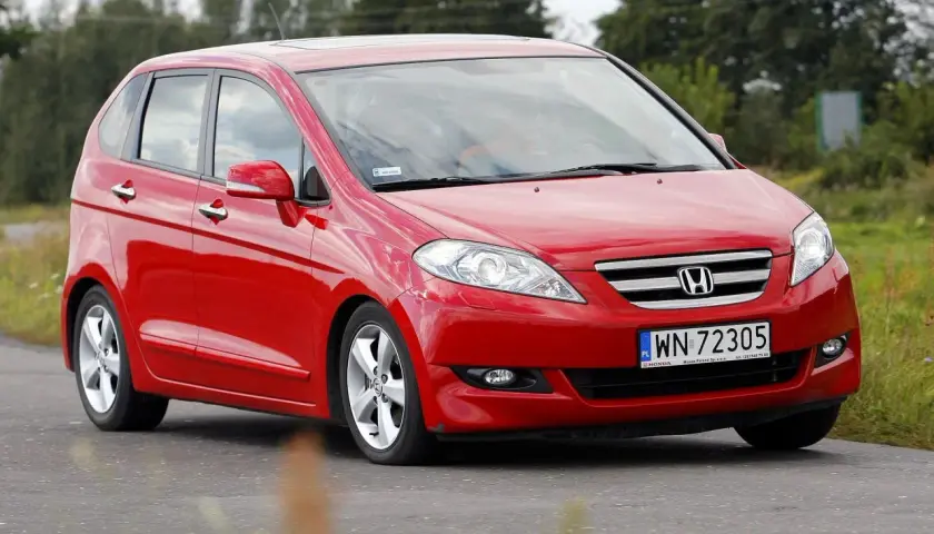 Czerwona Honda FR-V w ruchu drogowym, z widocznym numerem rejestracyjnym WN 72305.