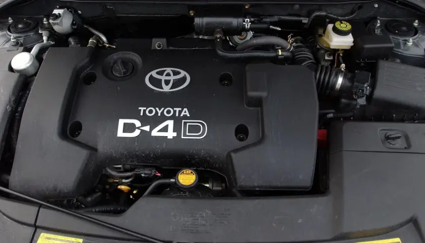 Silnik D-4D w Toyocie Avensis T25. Widoczna czarna pokrywa silnika z logo Toyoty i napisem D-4D.