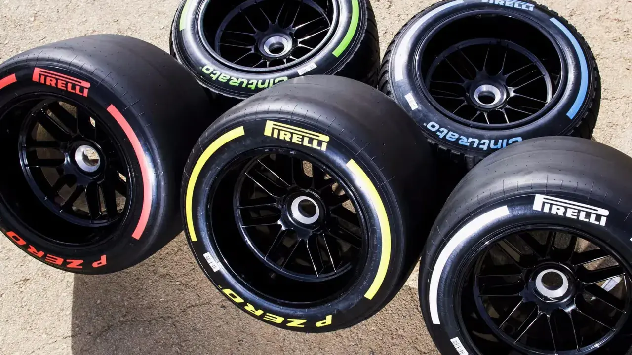 Pięć opon Pirelli F1 z kolorowymi paskami na bokach: czerwonym, żółtym, niebieskim, zielonym i białym.