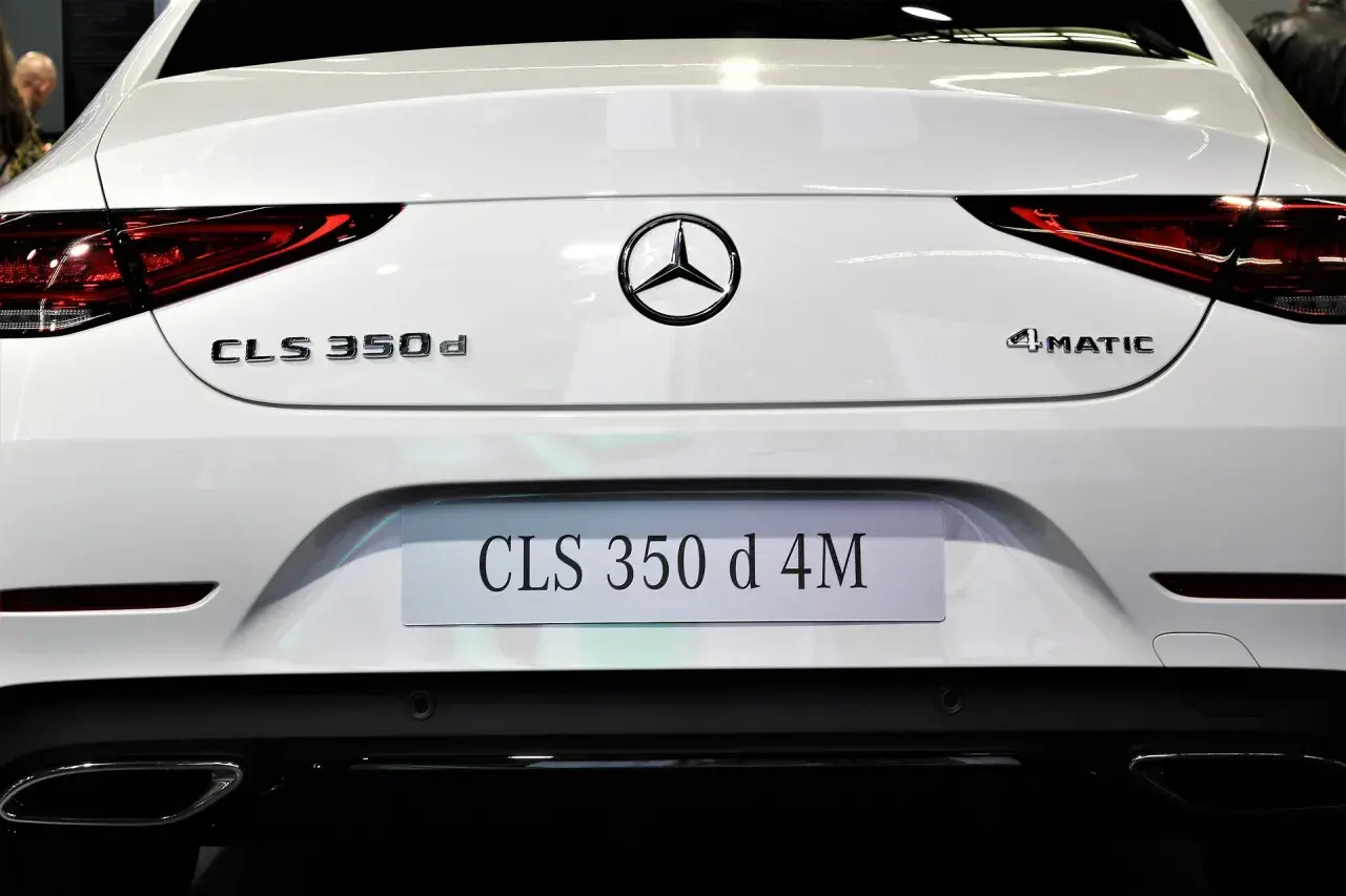 Tył białego Mercedesa CLS 350 d 4MATIC. Widoczne oznaczenia modeli i logo marki.