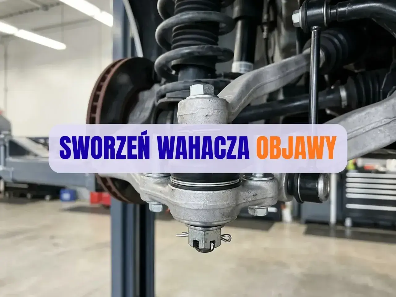 Zbliżenie na sworzeń wahacza samochodu w warsztacie.