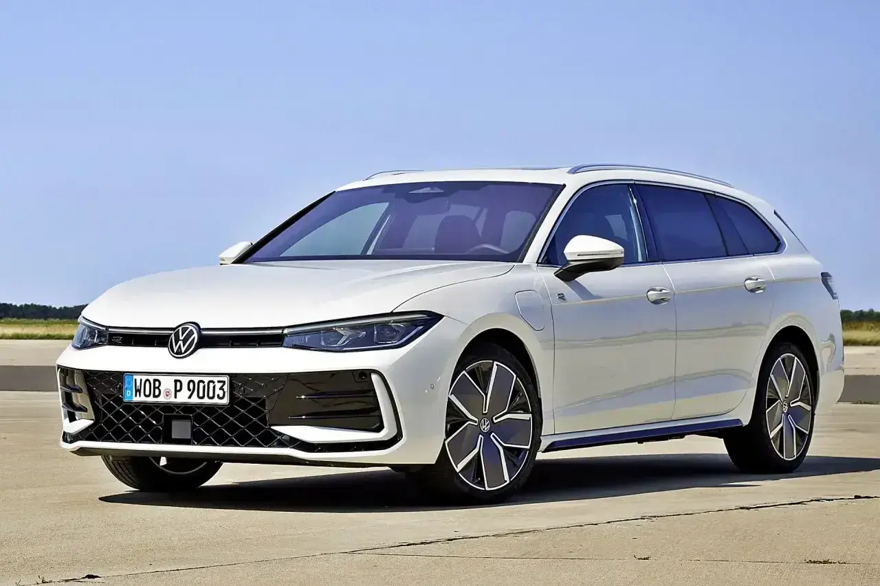 Biały Volkswagen Passat B9 Variant z nowoczesnymi felgami stoi na betonie, z błękitnym niebem w tle.