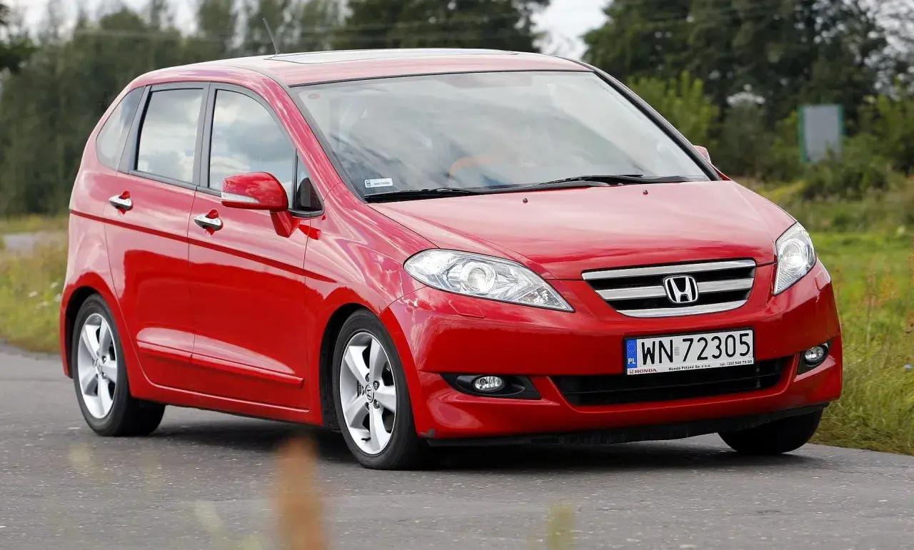Czerwona Honda FR-V w ruchu drogowym, z widocznym numerem rejestracyjnym WN 72305.