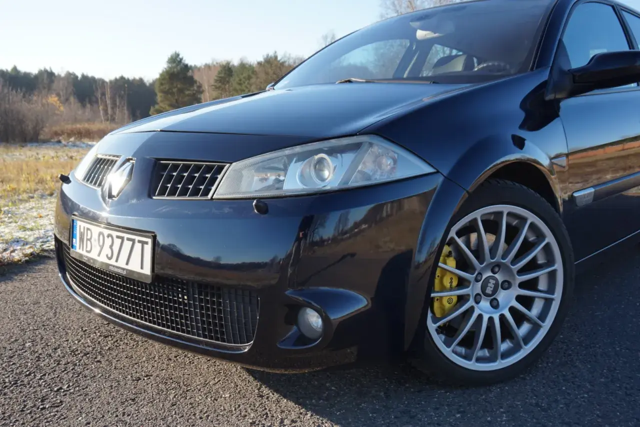 Ciemnoniebieski Renault Megane 2 z żółtymi zaciskami hamulcowymi Brembo na alufelgach.