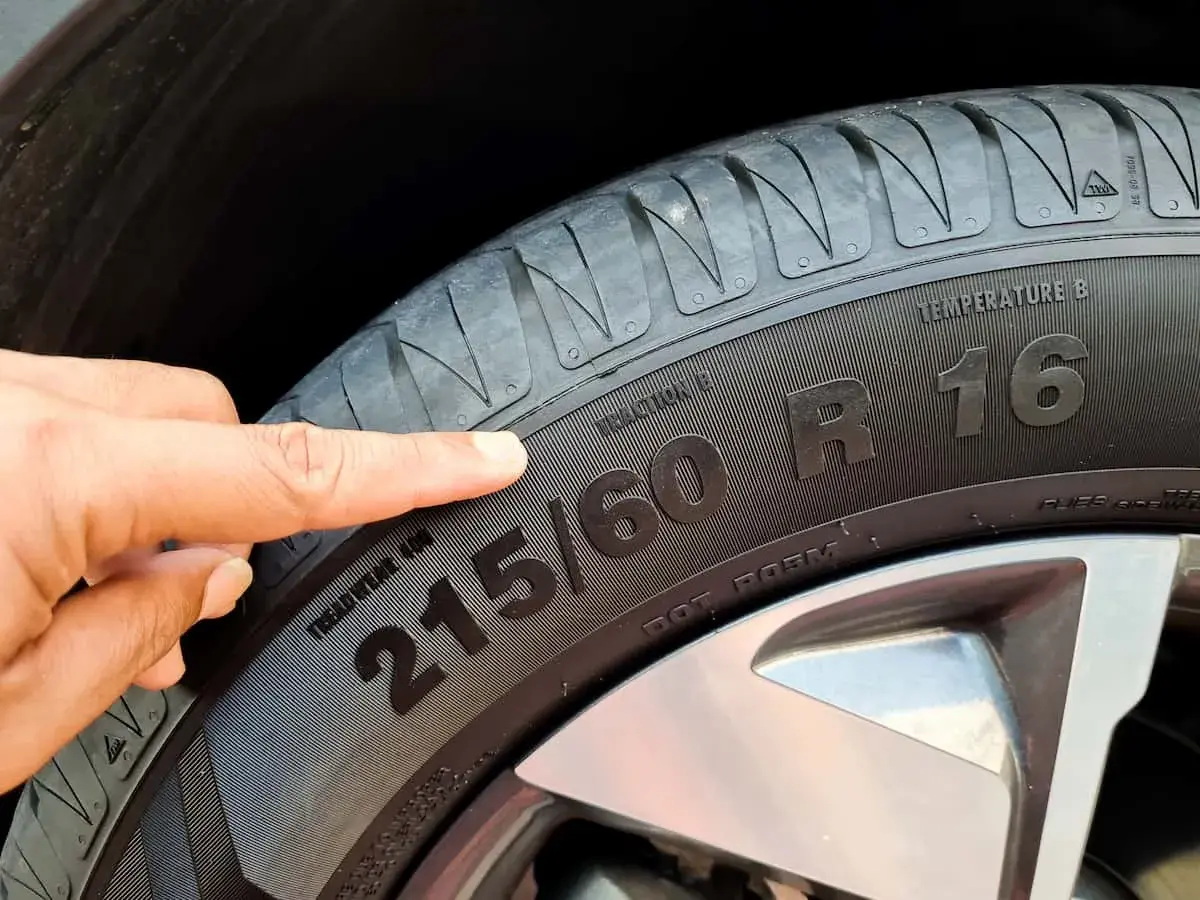 Palec wskazujący na oznaczenie opony 215/60 R16.