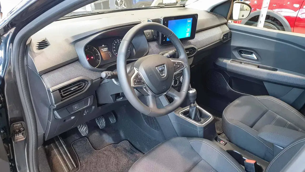 Wnętrze Dacia Supernova: kierownica, deska rozdzielcza z ekranem multimedialnym i cyfrowymi zegarami, dźwignia zmiany biegów, fotele.