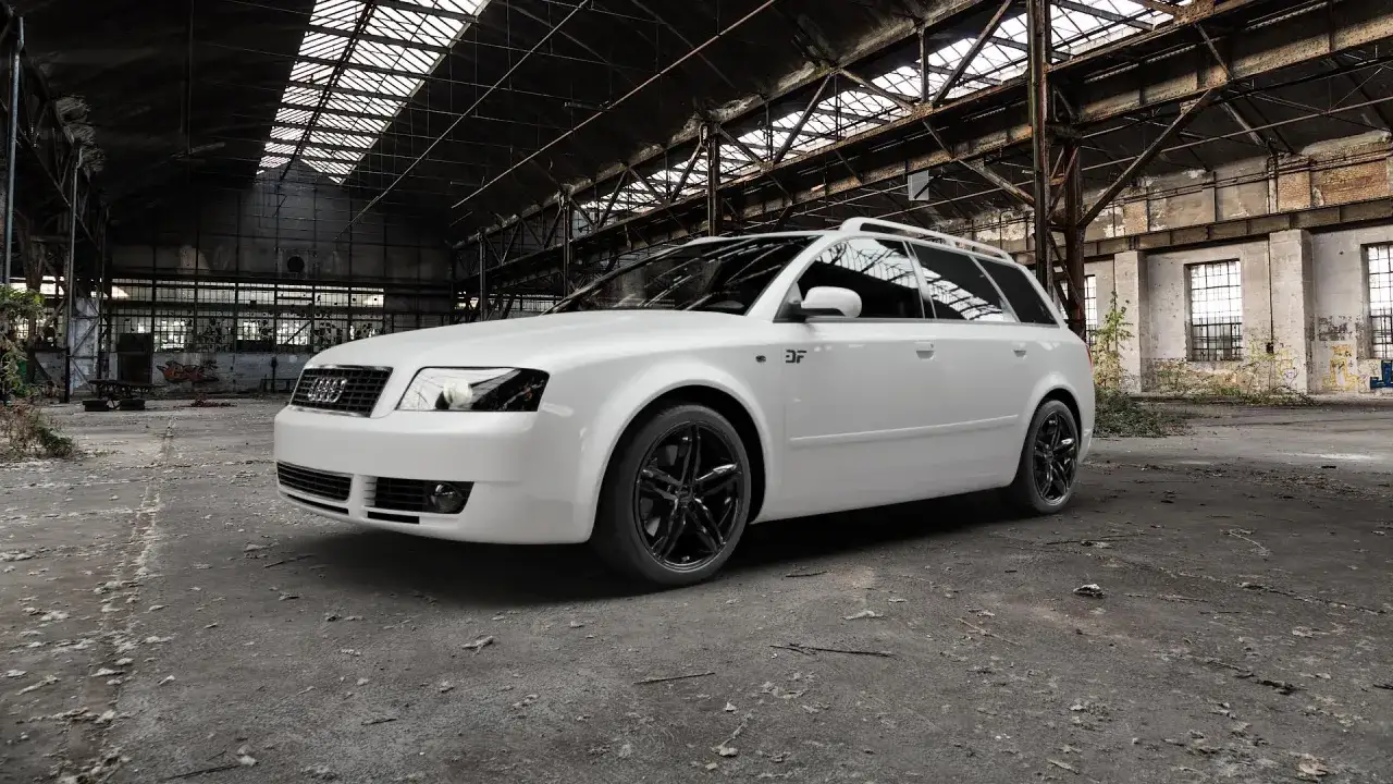 Białe Audi A4 B6 Avant, wyprodukowane w latach 2000-2006, stoi w opuszczonej hali fabrycznej.