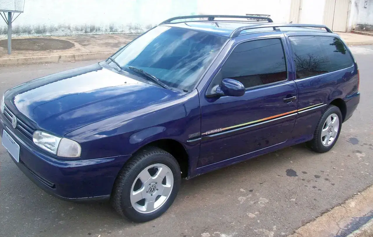 Granatowy VW Parati z kolorowymi pasami na boku i relingami dachowymi, gotowy na letnie podróże.