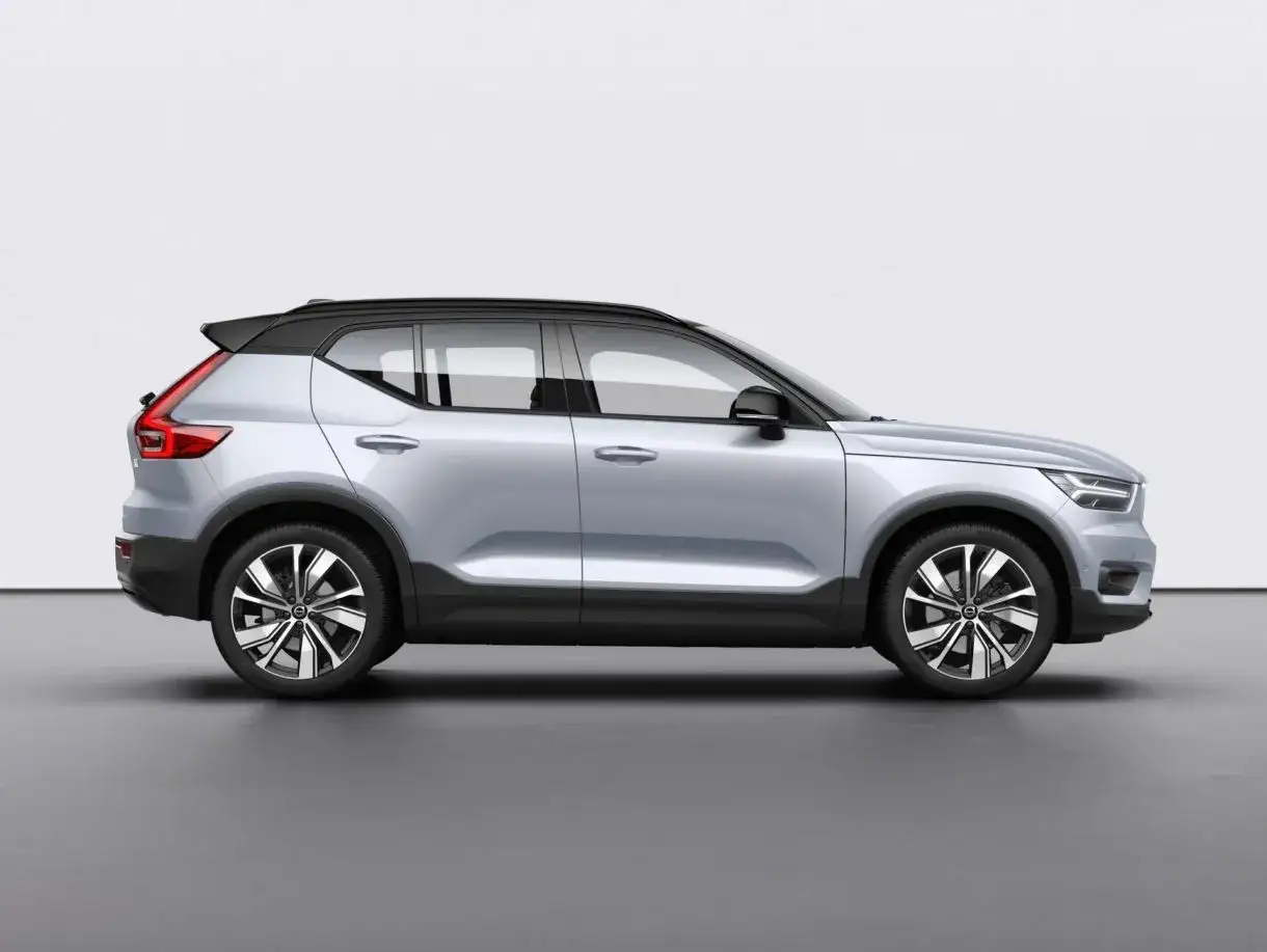 Srebrny Volvo XC100 z czarnym dachem i przyciemnianymi szybami, prezentowany z boku na szarym tle.