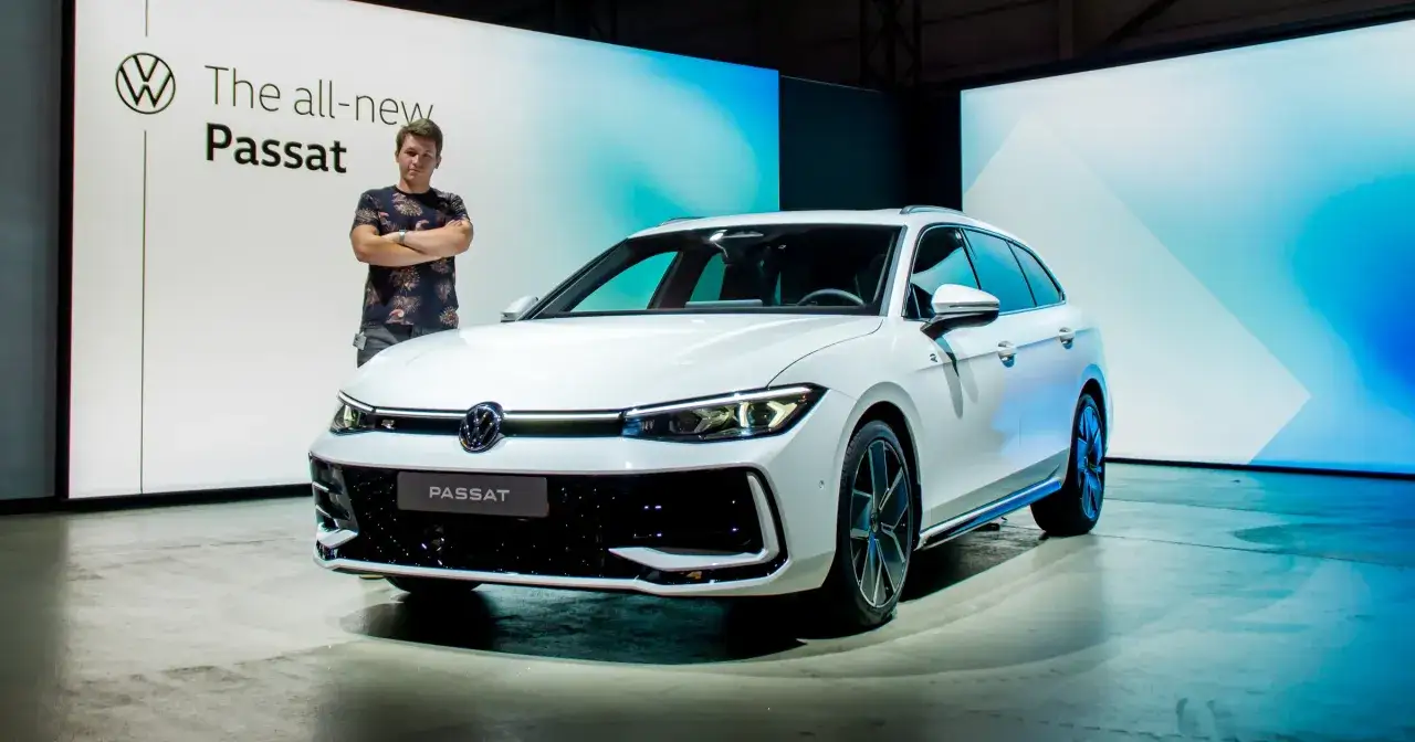 Mężczyzna stoi obok białego kombi, prezentując nowy Passat B9.