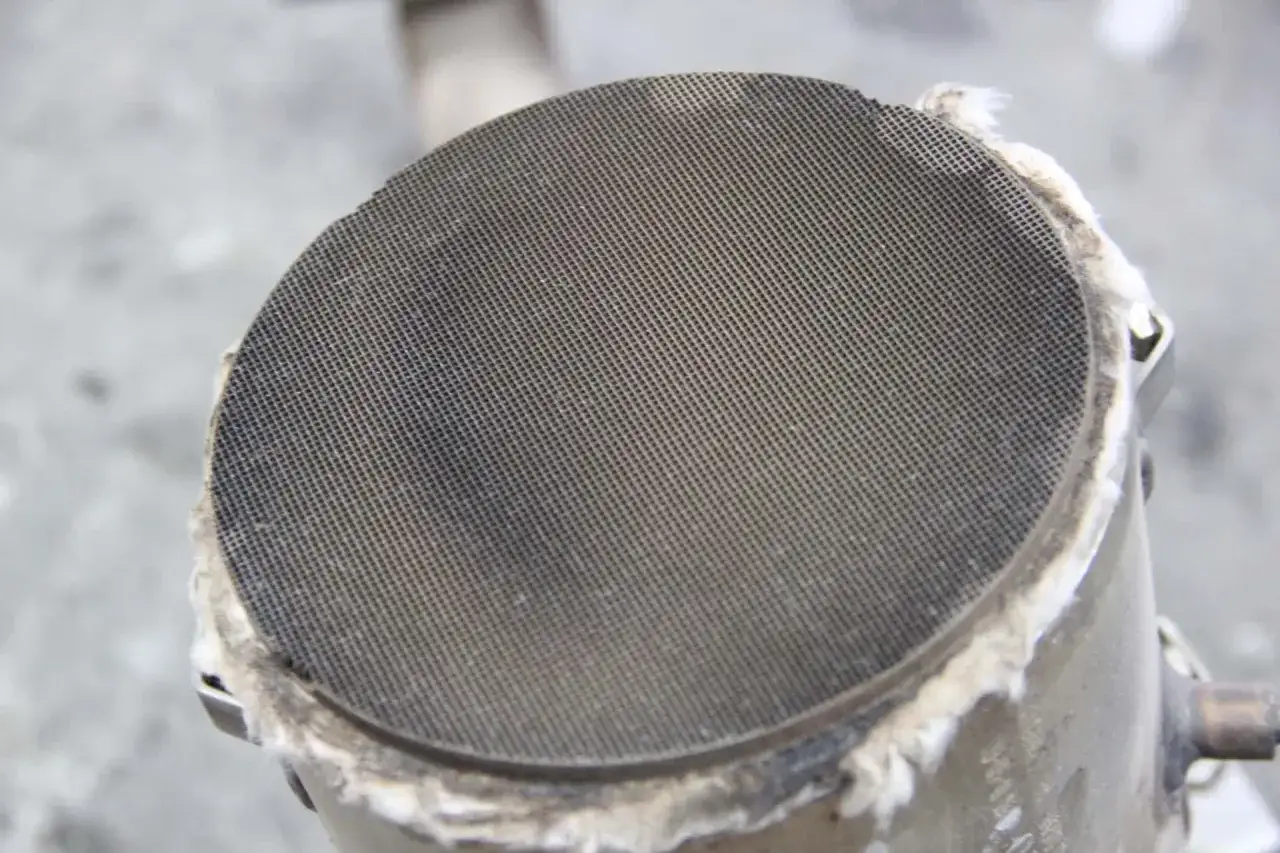 Widok z bliska na zapchany fap, z widoczną siatką filtra i izolacją.