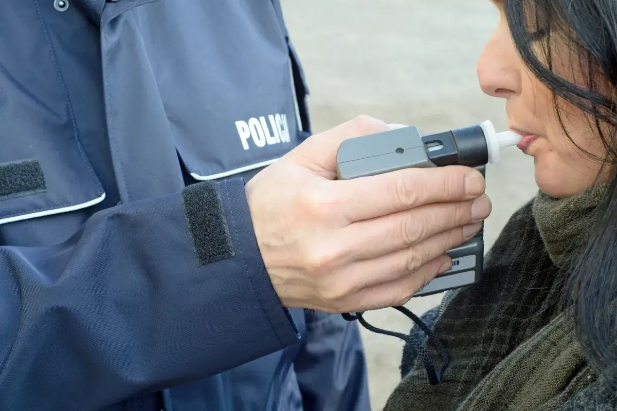 osoba dmuchająca w alkomat