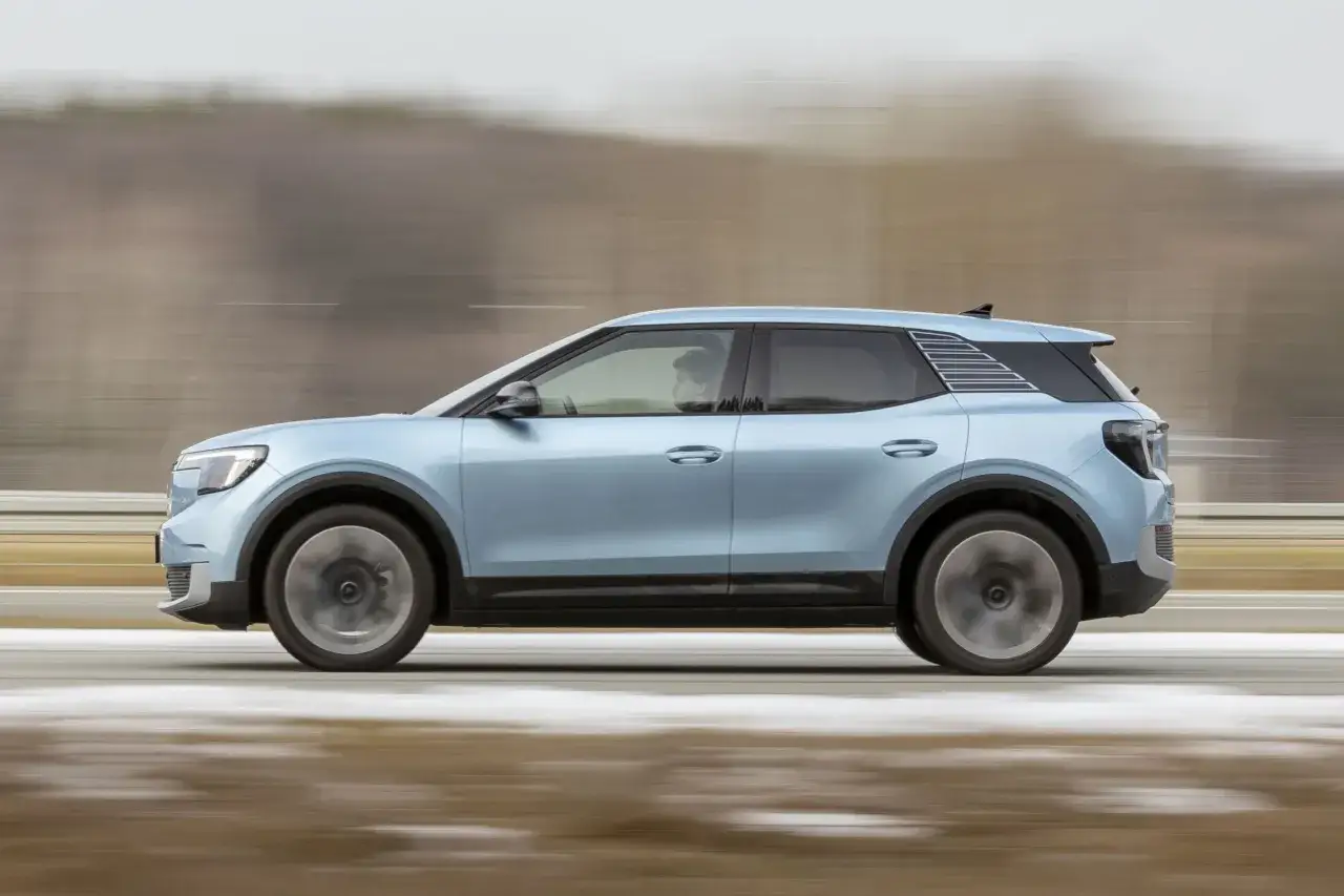 Błękitny Ford Explorer Sport w ruchu, z rozmytym tłem sugerującym prędkość.
