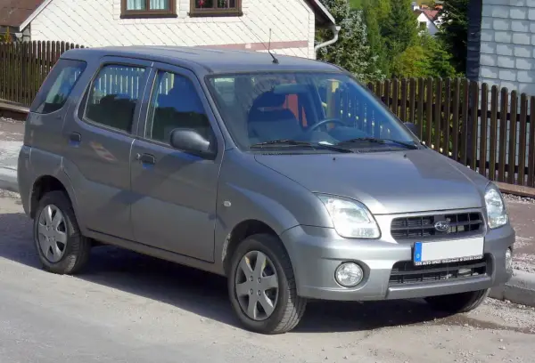 Szary Subaru Justy G3X stoi na drodze, gotowy na przygodę.